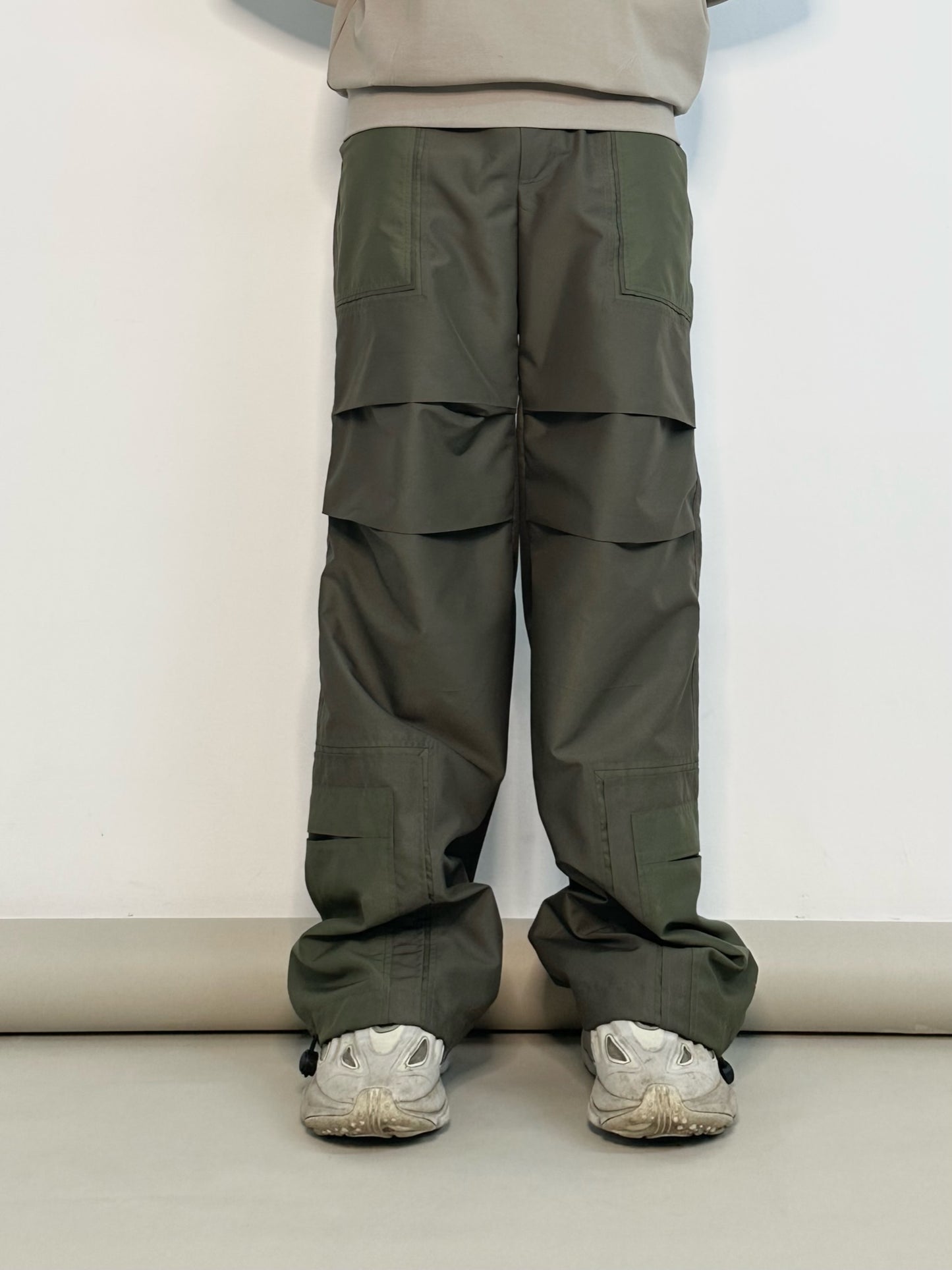 parachute pants, cut and sew, mens parachute pants, mens streetwear style, limited edition, warping theories, womenswear style, womens parachute pants, odark green parachute pants, cut and sew detailiing, cut and sew pants, summer colloection parachute pants, styling inspiration, people also ask 